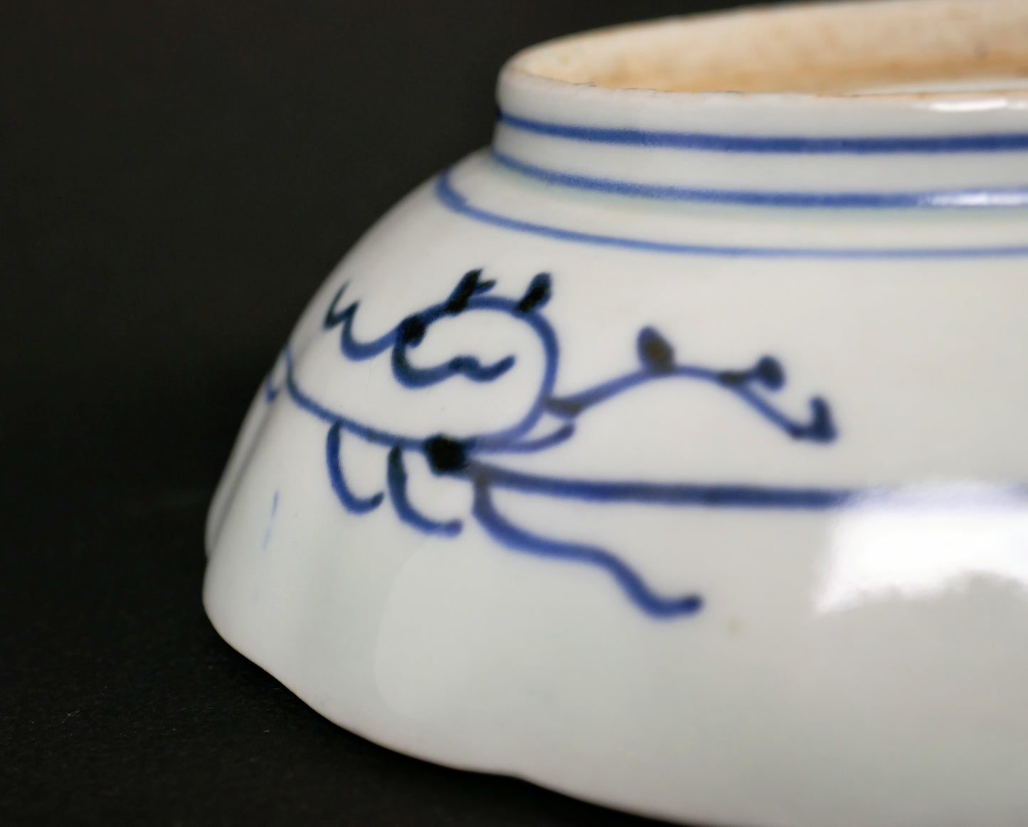 Décor végétal stylisé peint au cobalt sur le revers d’une assiette japonaise ancienne en porcelaine