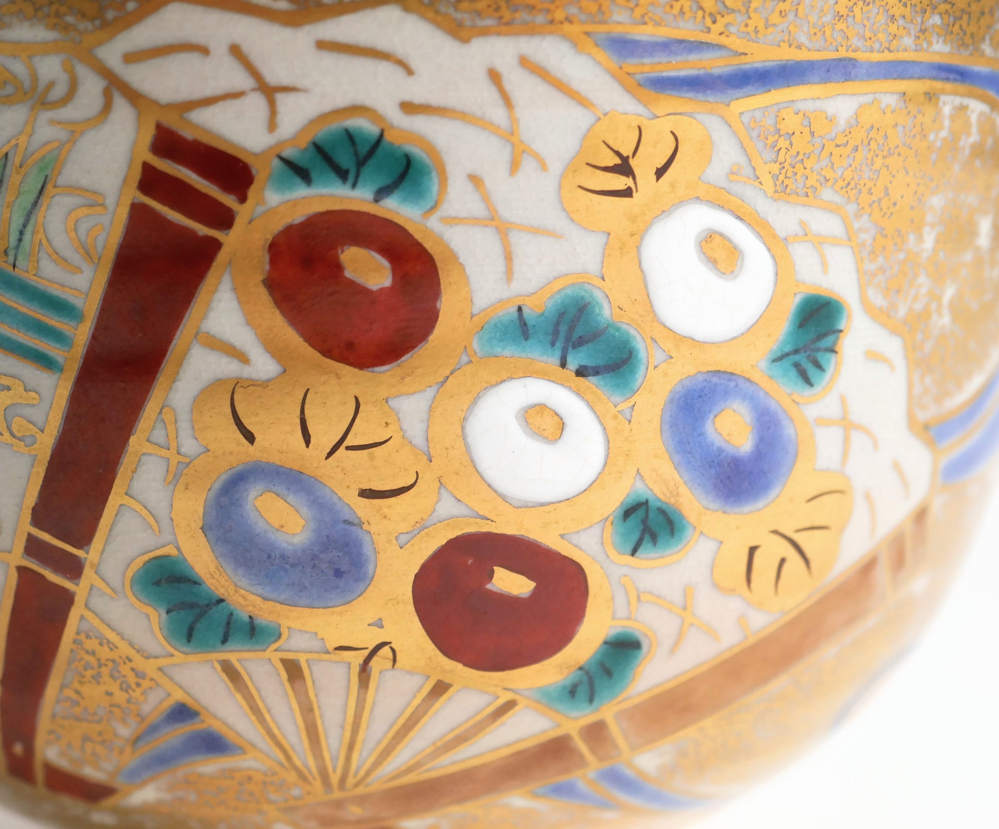 Détail d’un éventail du chawan de style Ninsei, orné de fleurs rondes polychromes, de feuilles turquoise et de contours dorés.