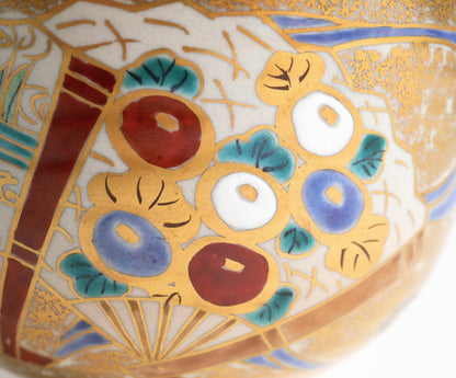 Détail d’un éventail du chawan de style Ninsei, orné de fleurs rondes polychromes, de feuilles turquoise et de contours dorés.