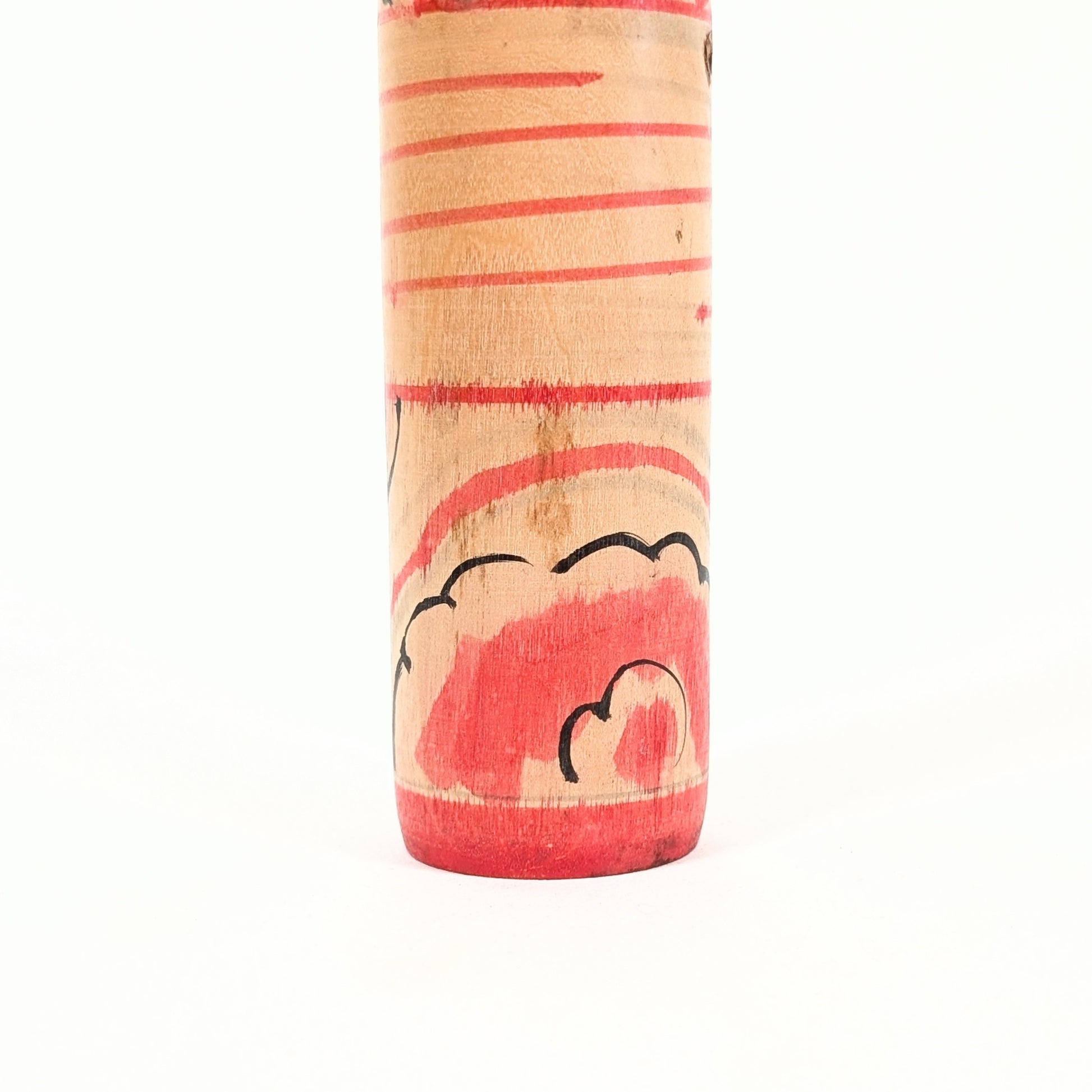 Détail du décor rouge sur le bas du corps d’une dentō kokeshi Nakanosawa.