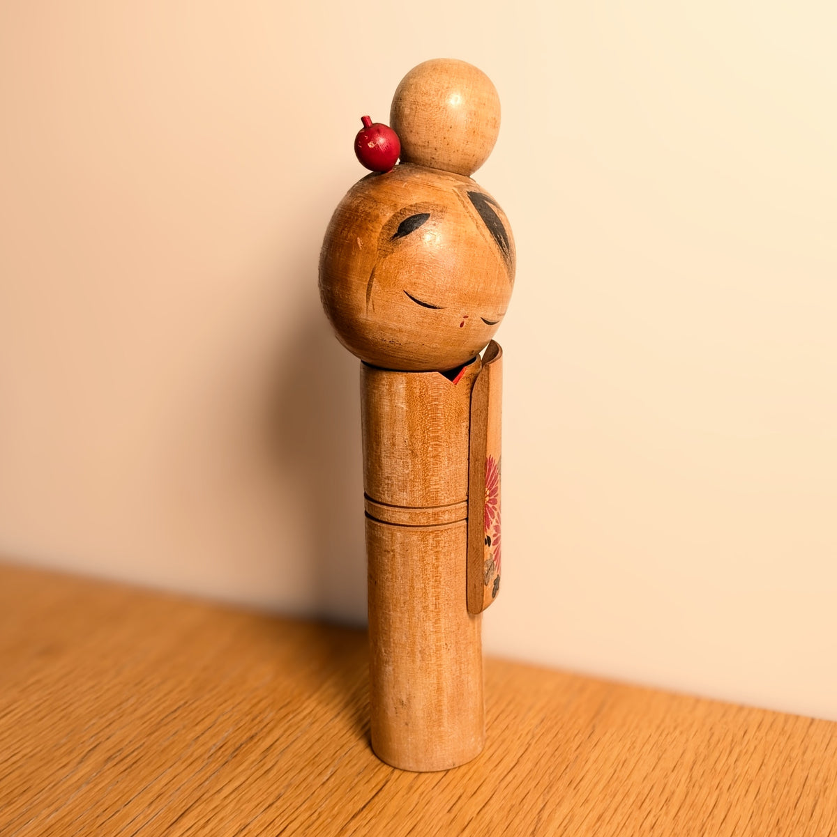 Kokeshi sōsaku vintage de 25 cm présentée en décoration japonaise, silhouette élancée en bois et kimono fleuri