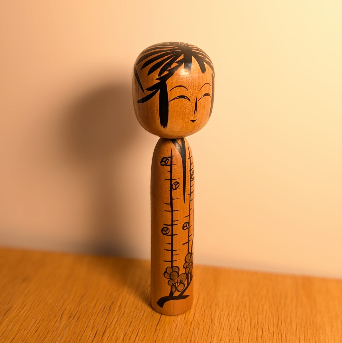Grande kokeshi japonaise vintage de 31 cm, décorée de fleurs de prunier, présentée dans une ambiance chaleureuse et épurée.