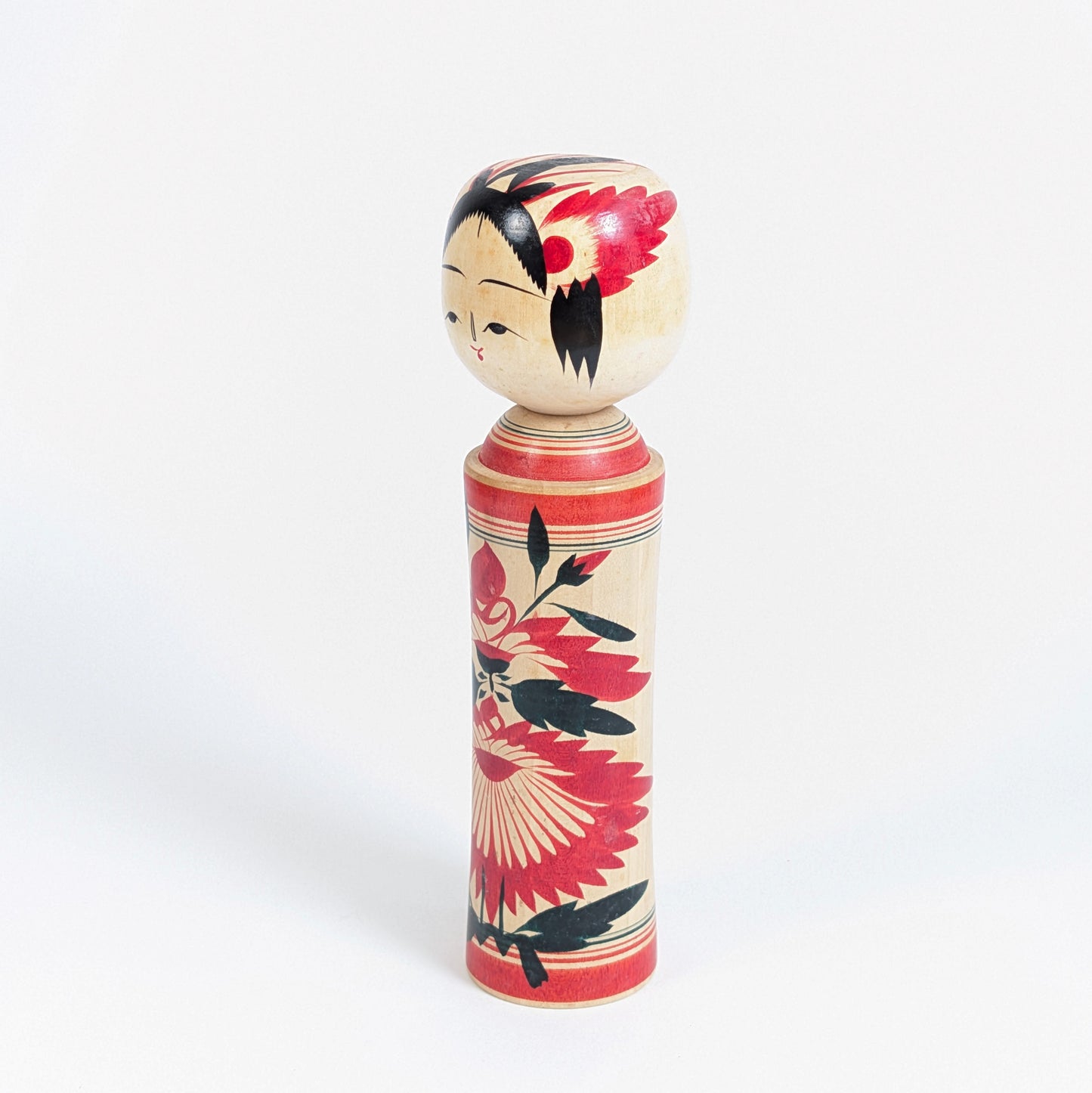 Kokeshi dentō de Naruko, Miyagi, avec silhouette traditionnelle en bois tourné, visage peint et grand décor floral rouge et noir.