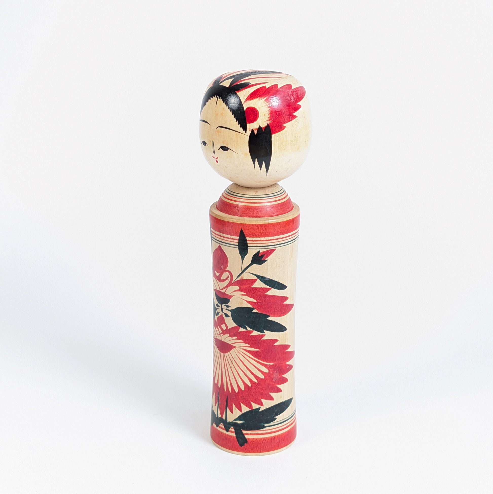 Kokeshi dentō de Naruko, Miyagi, avec silhouette traditionnelle en bois tourné, visage peint et grand décor floral rouge et noir.