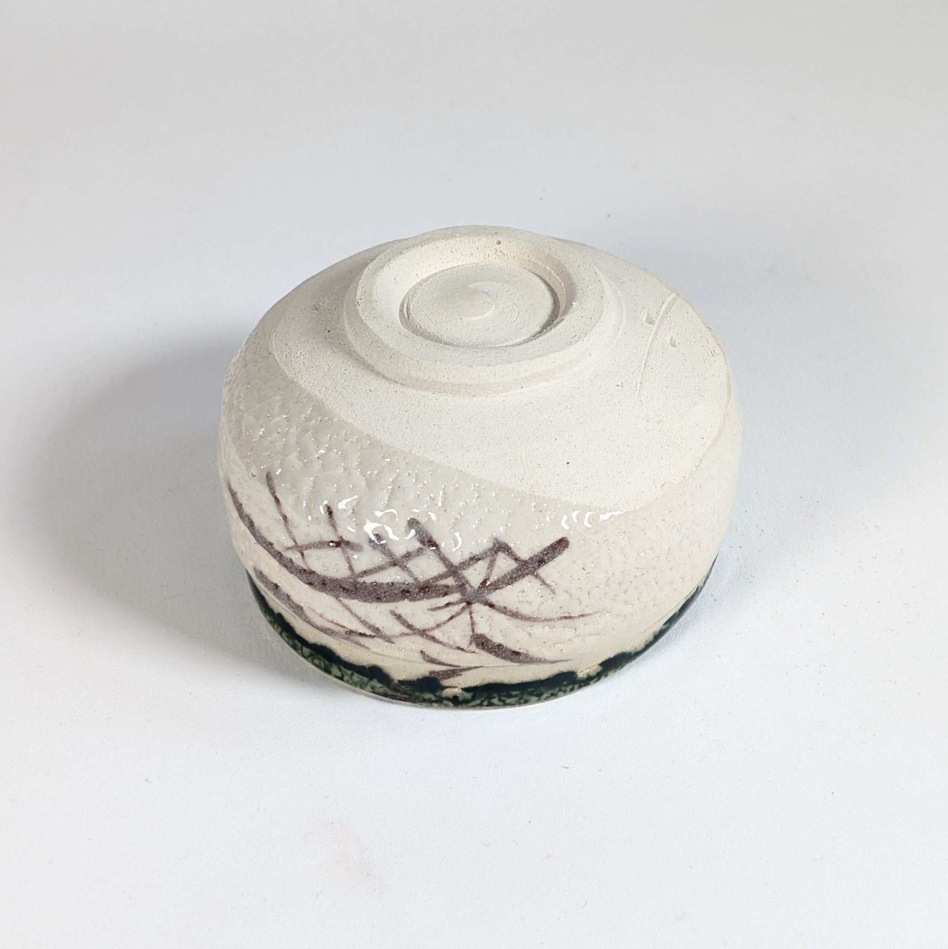 Dessous du bol matcha Oribe avec décor brun gestuel, pied tourné et texture de poterie japonaise