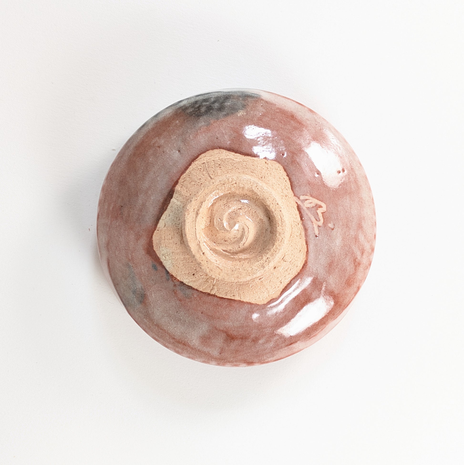 Dessous du bol matcha raku avec pied kōdai spiralé, terre apparente et signature du potier