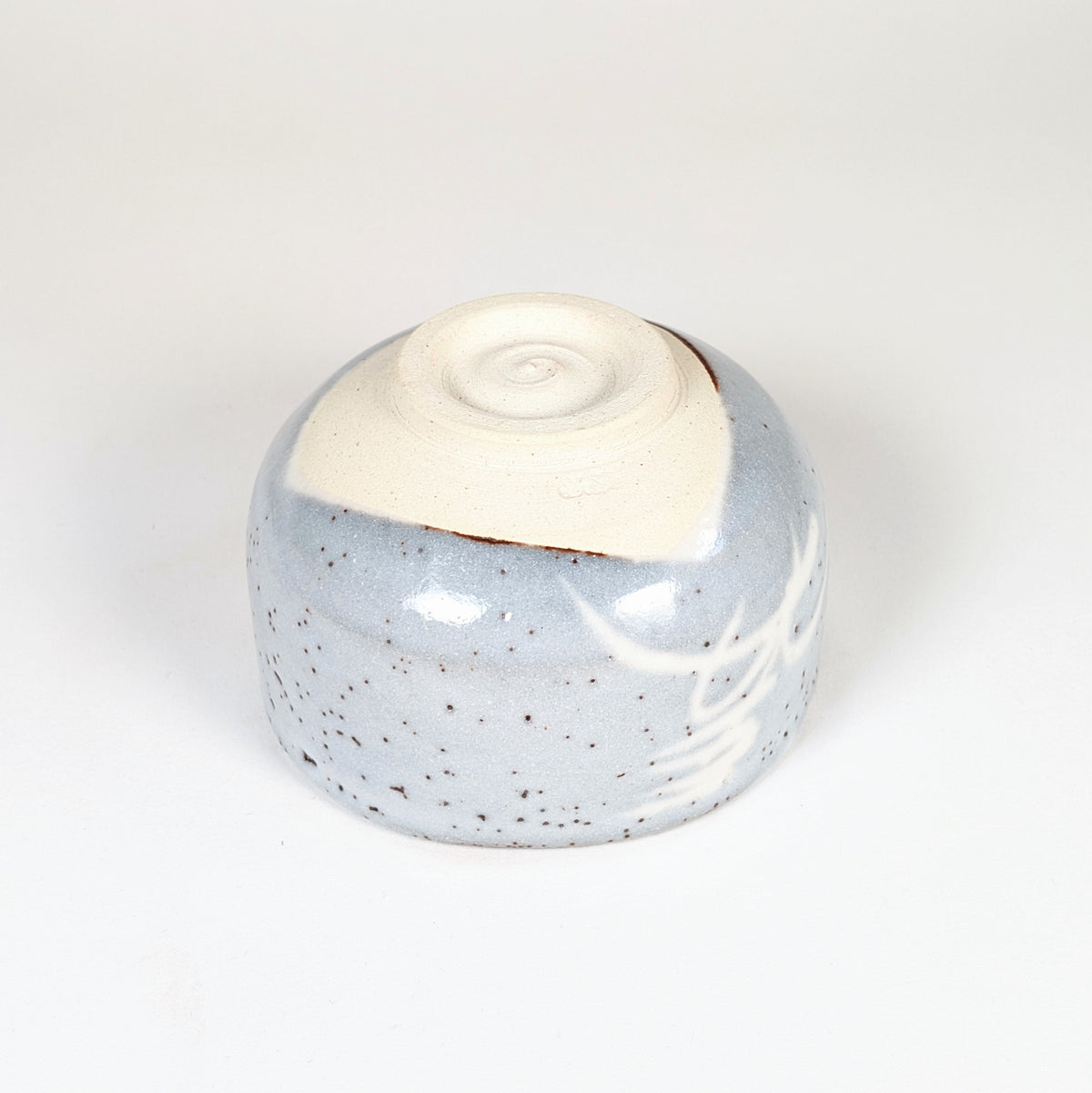 Dessous du chawan japonais Mino-yaki montrant le kōdai tourné, le pied non émaillé et la terre claire.