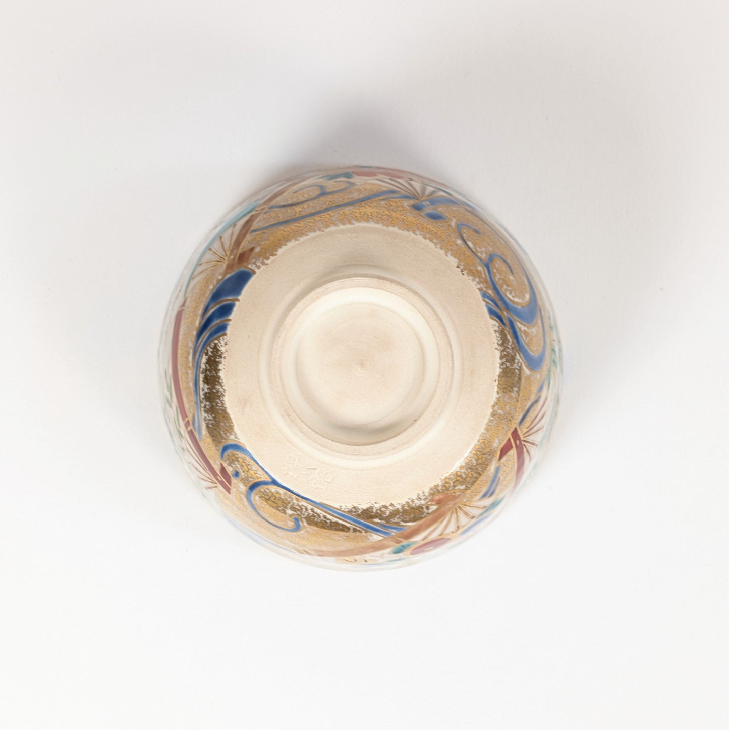 Vue du dessous du chawan de Shōzaemon avec kōdai annulaire, traces de tournage et décor doré de la céramique Kyō-yaki.