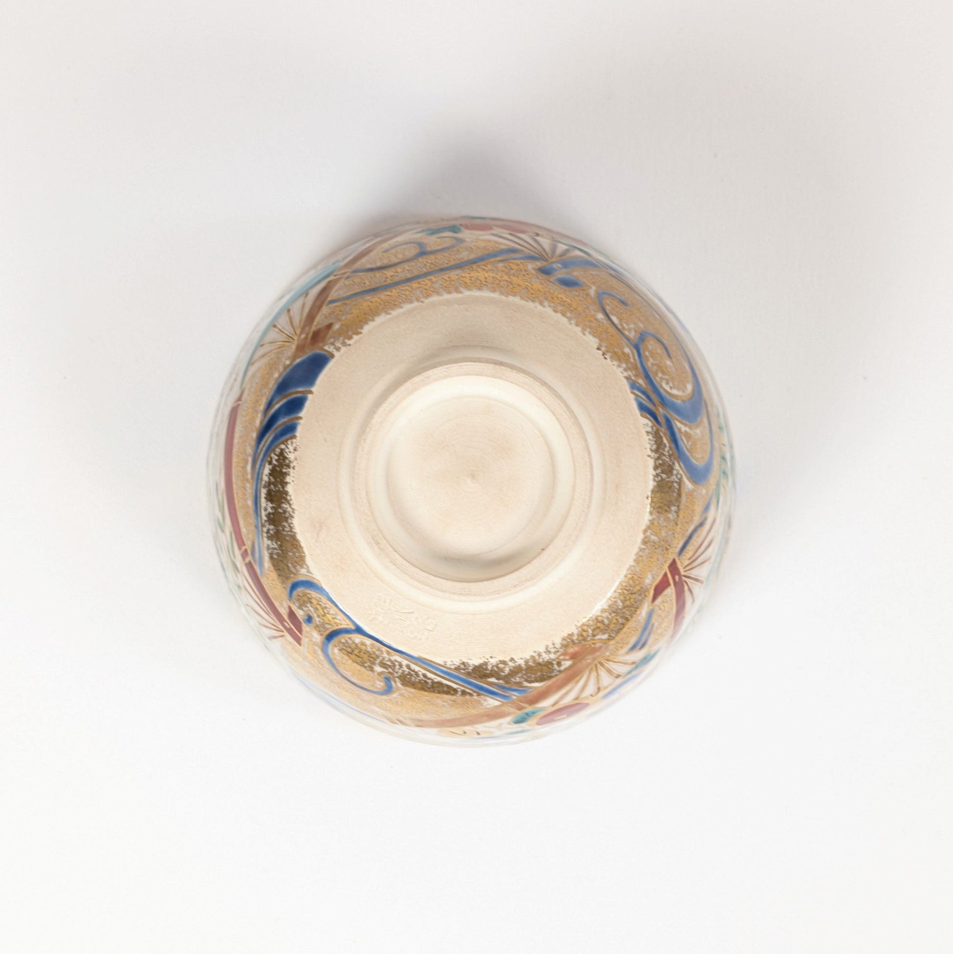 Vue du dessous du chawan de Shōzaemon avec kōdai annulaire, traces de tournage et décor doré de la céramique Kyō-yaki.