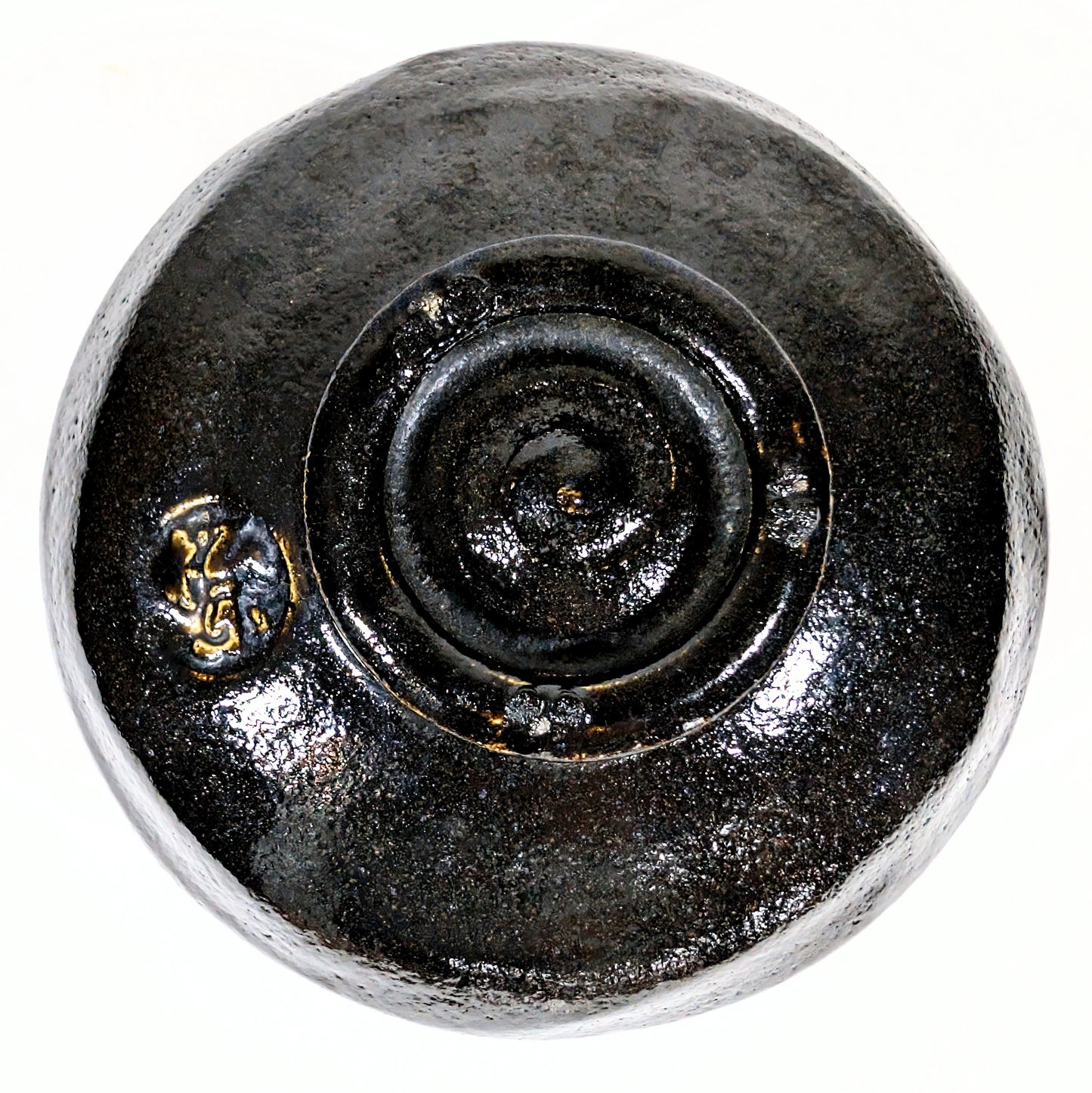 Vue du dessous d’un chawan en raku noir, montrant le pied tourné et la marque du potier Sasaki Shoraku.