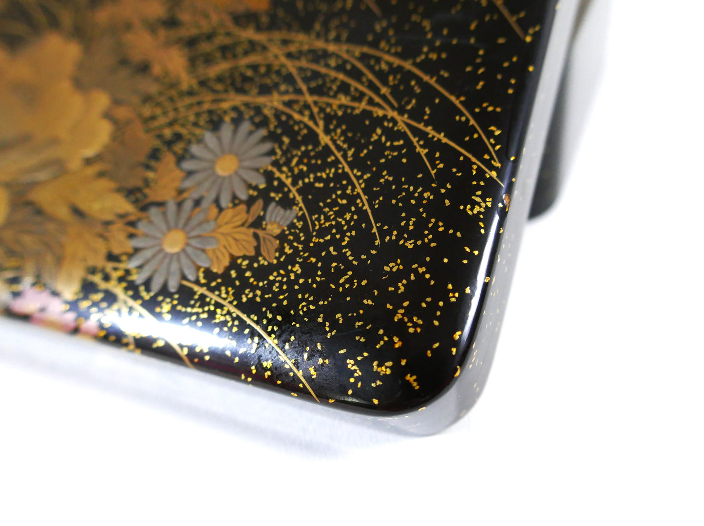 Angle décoré de chrysanthèmes en maki-e doré sur boîte laquée noire signée Zohiko Kyoto.