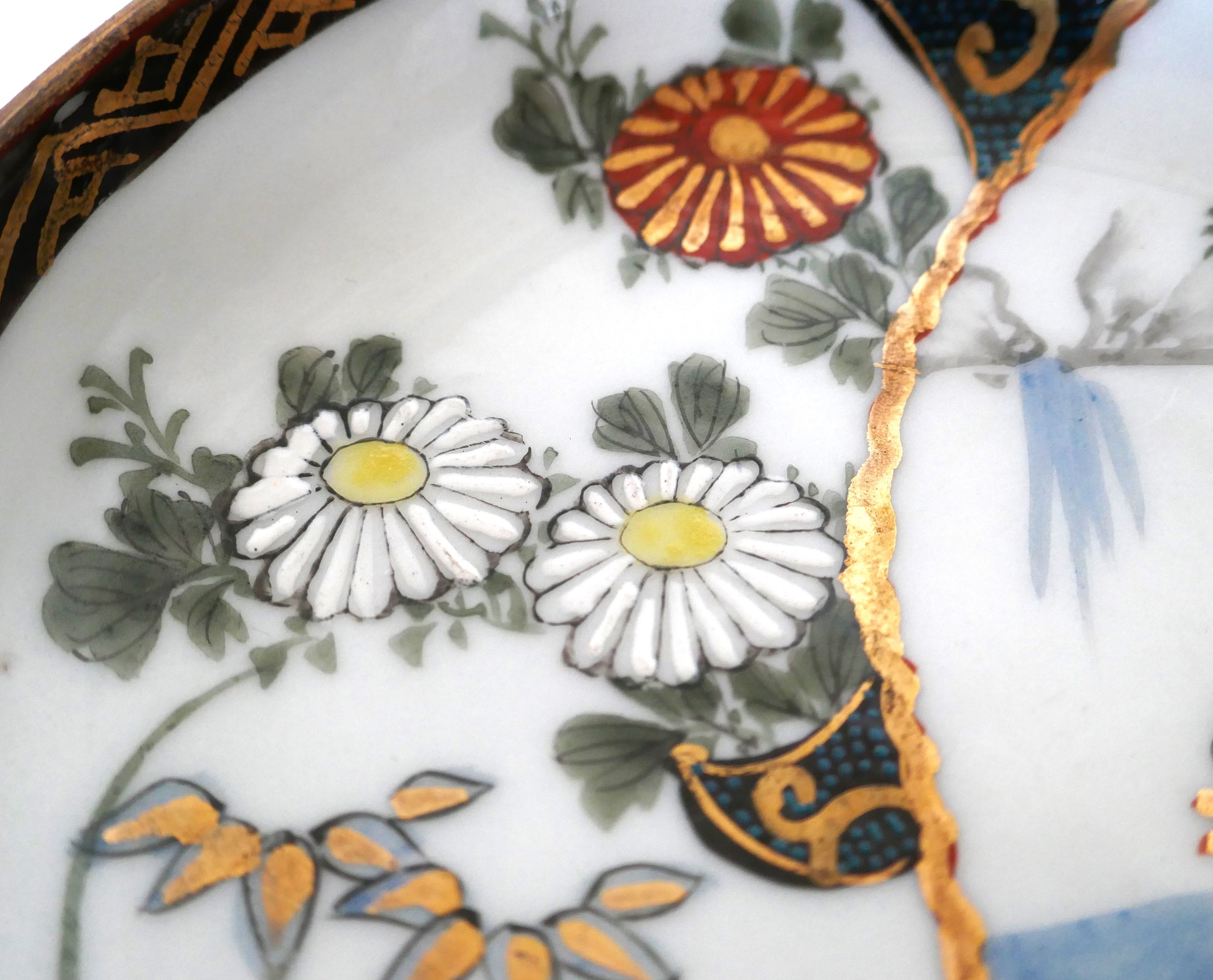 Détail des fleurs de chrysanthème avec émail en relief et dorures sur assiette japonaise Kutani