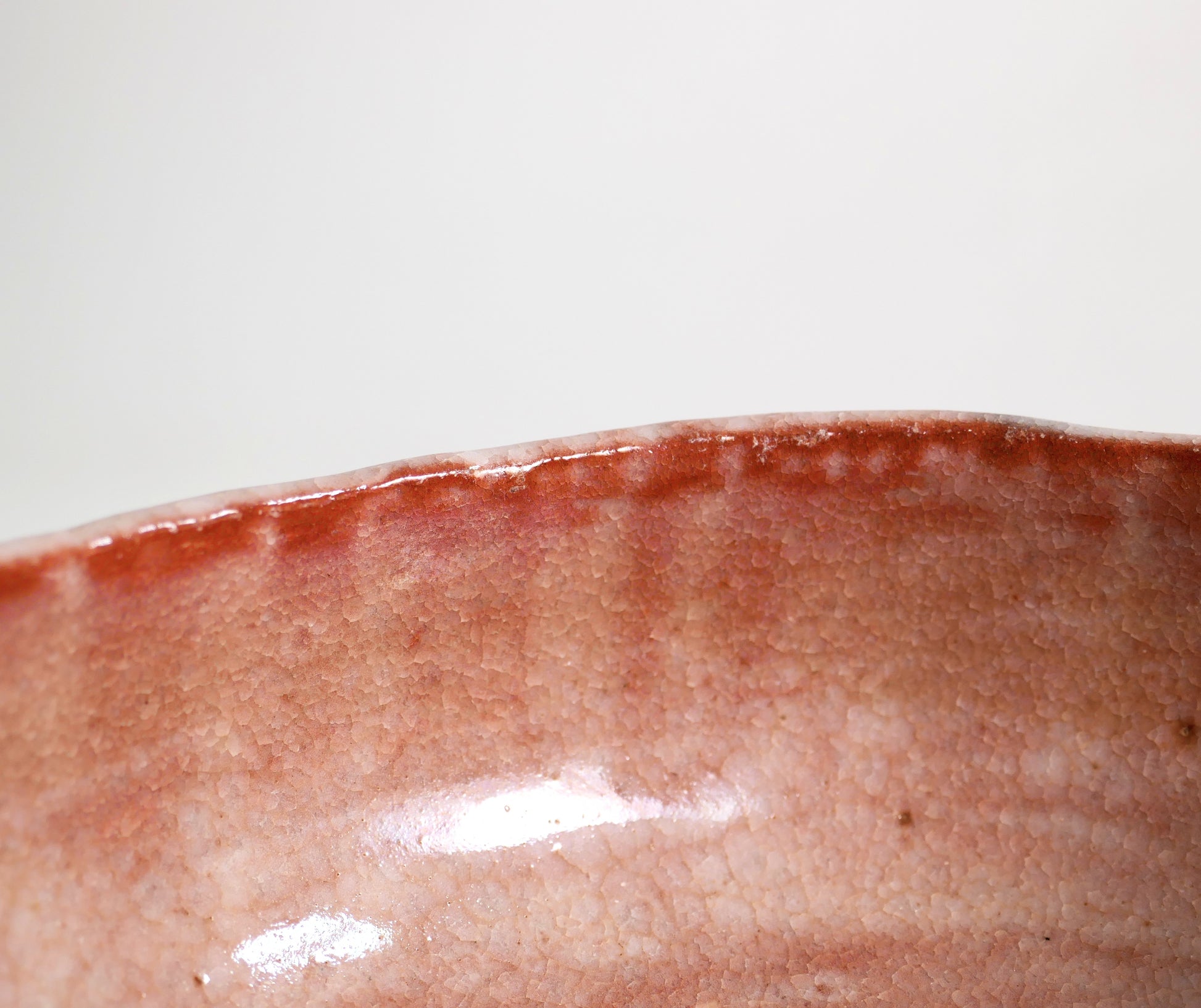 Détail du bord intérieur d’un chawan aka raku rose avec émail rouge rosé et fine craquelure kanyū