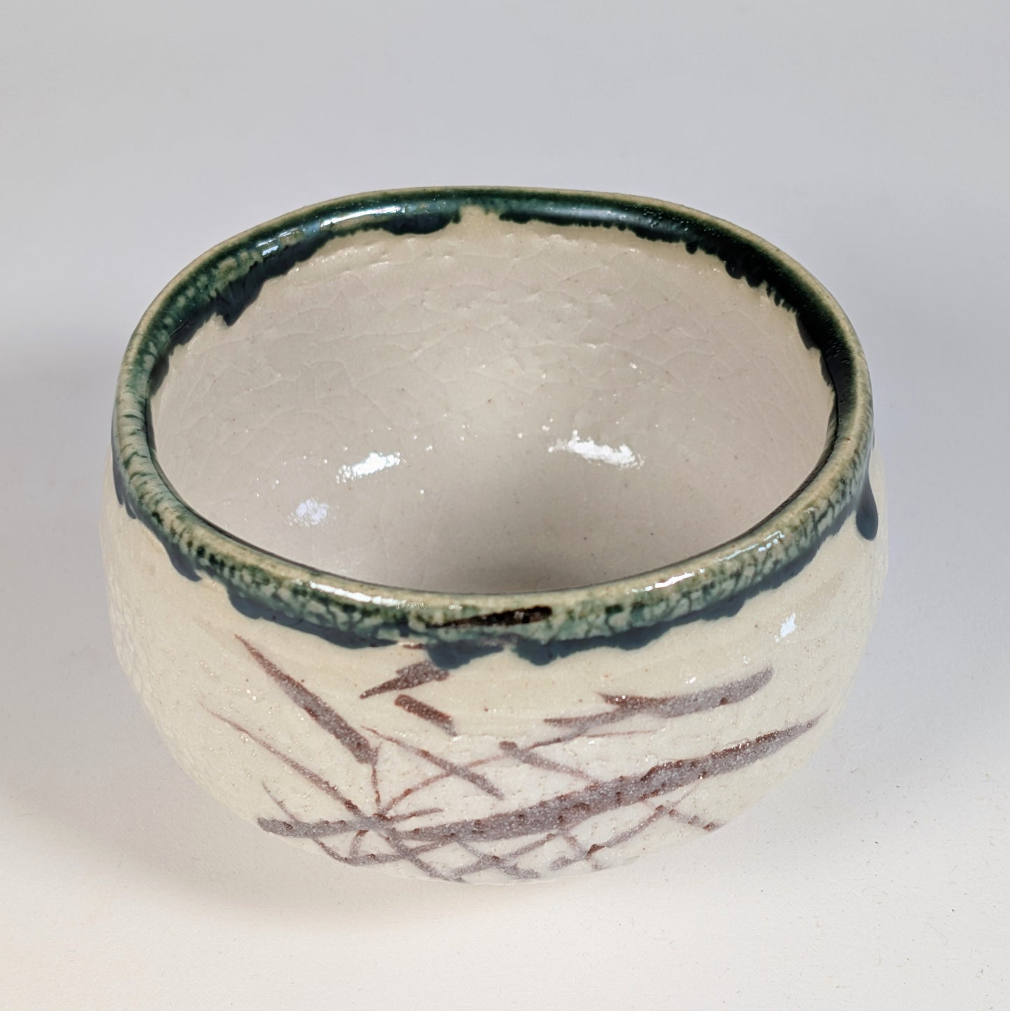 Détail du chawan Oribe avec glaçure verte au cuivre, motifs bruns et émail craquelé, atelier Kikyōya-gama