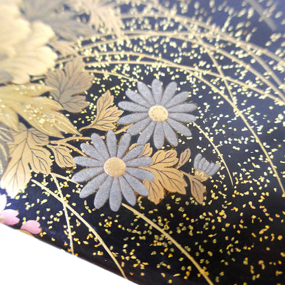 Détail de chrysanthèmes en argent maki-e sur laque noire Zohiko Kyoto, artisanat Taishō.