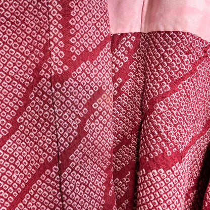 Détail du col d’un haori japonais ancien en soie shibori rose fuchsia, présentant une légère trace du temps, témoin de son authenticité.
