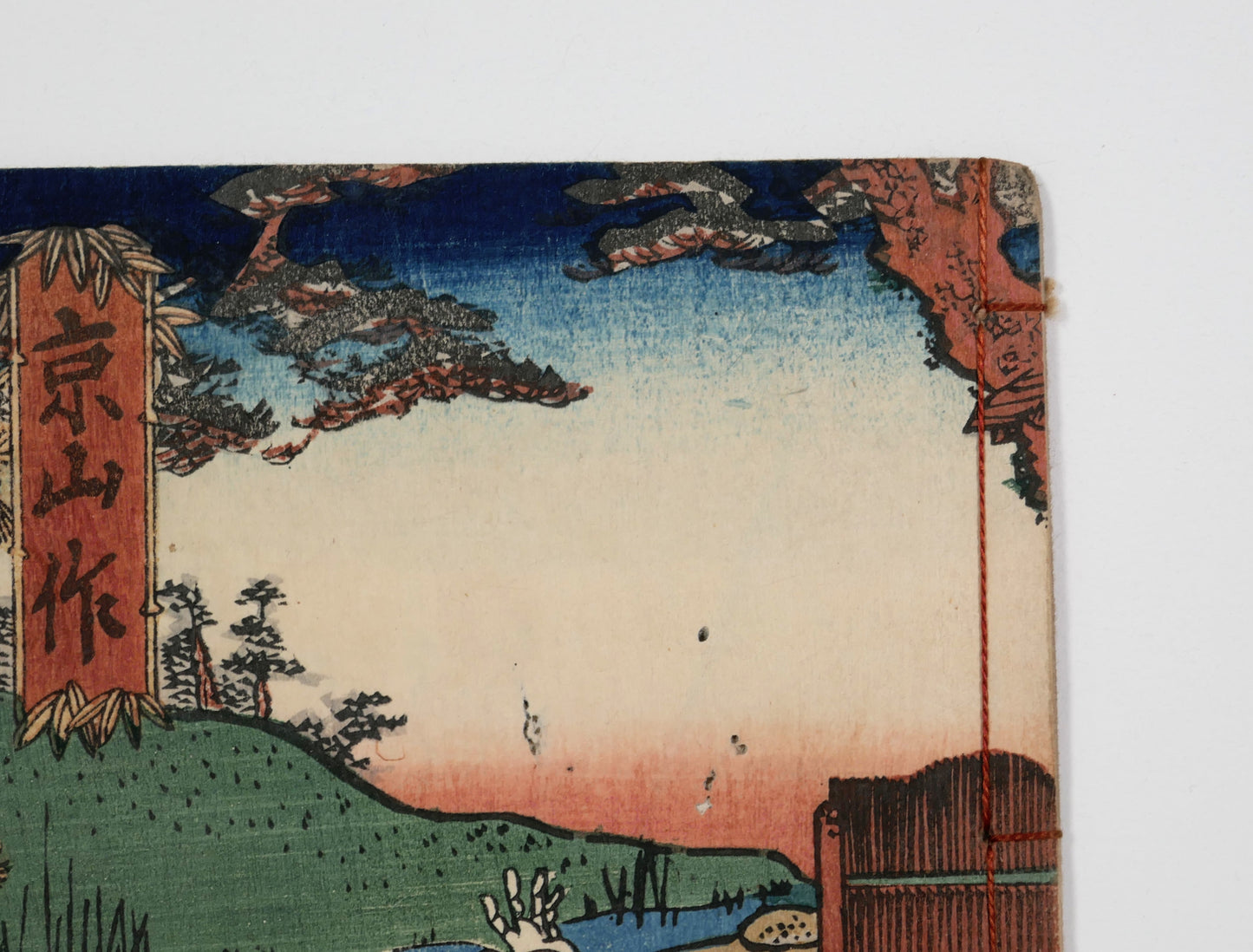 Détail supérieur de la couverture du Kinsei Bijin-roku, manga Edo original avec paysage de pins, ciel coloré et estampe japonaise ancienne.