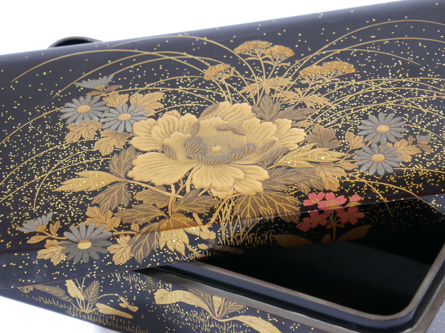 Gros plan sur la décoration florale dorée en maki-e sur boîte japonaise Zohiko Kyoto, artisanat urushi traditionnel.