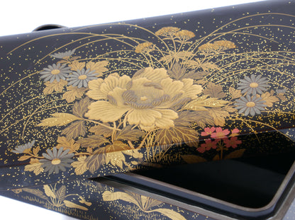 Gros plan sur la décoration florale dorée en maki-e sur boîte japonaise Zohiko Kyoto, artisanat urushi traditionnel.