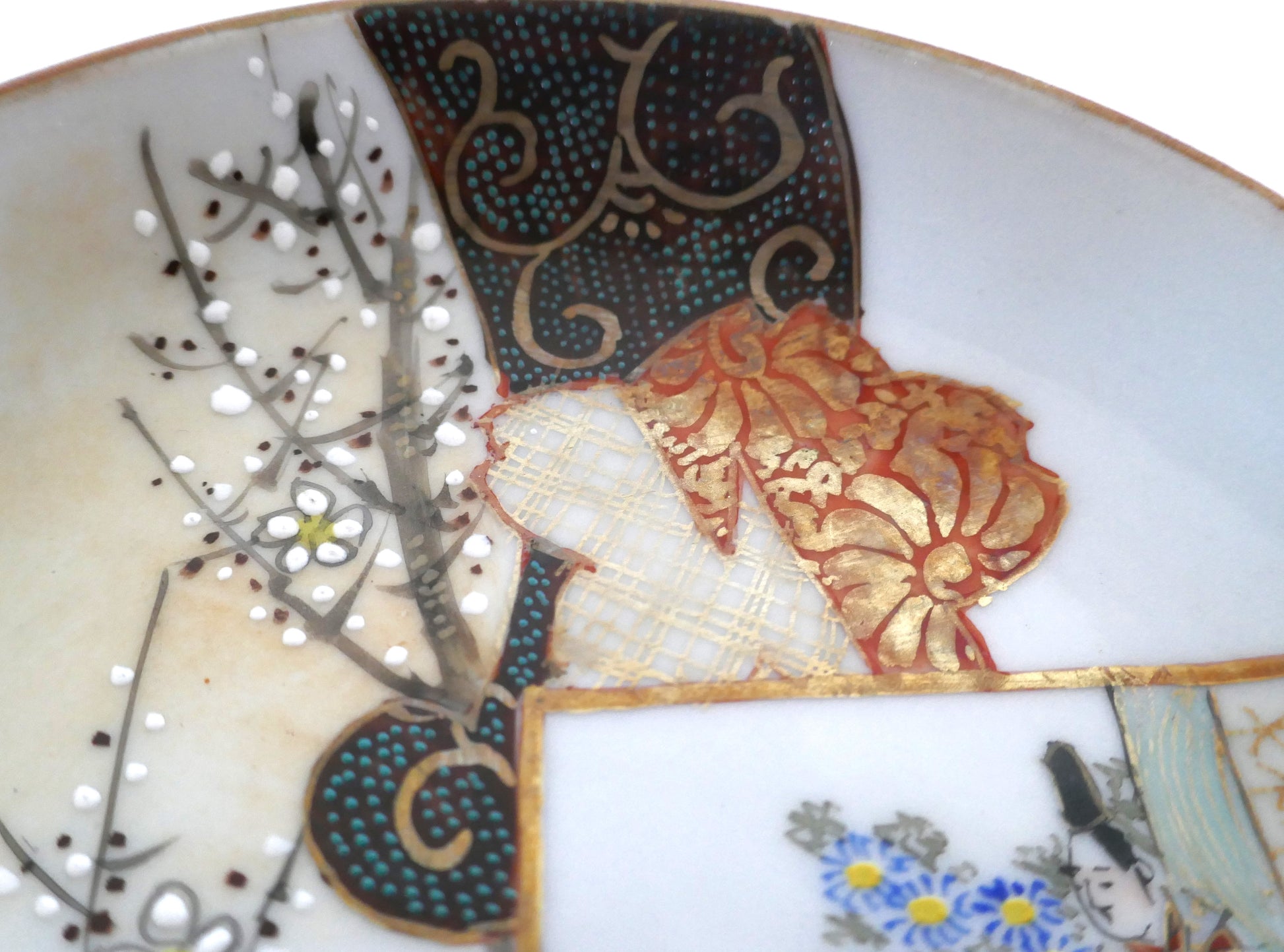 Détail des dorures et motifs textiles traditionnels peints à la main sur une assiette Kutani ancienne