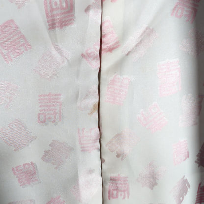 Détail de la doublure d’un haori en soie japonais avec motif kanji Kotobuki sur fond blanc