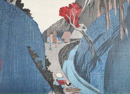 Vue rapprochée de l’estampe de Hiroshige avec la rivière, les porteurs et les maisons du village d’Okabe – série des 53 stations du Tokaido