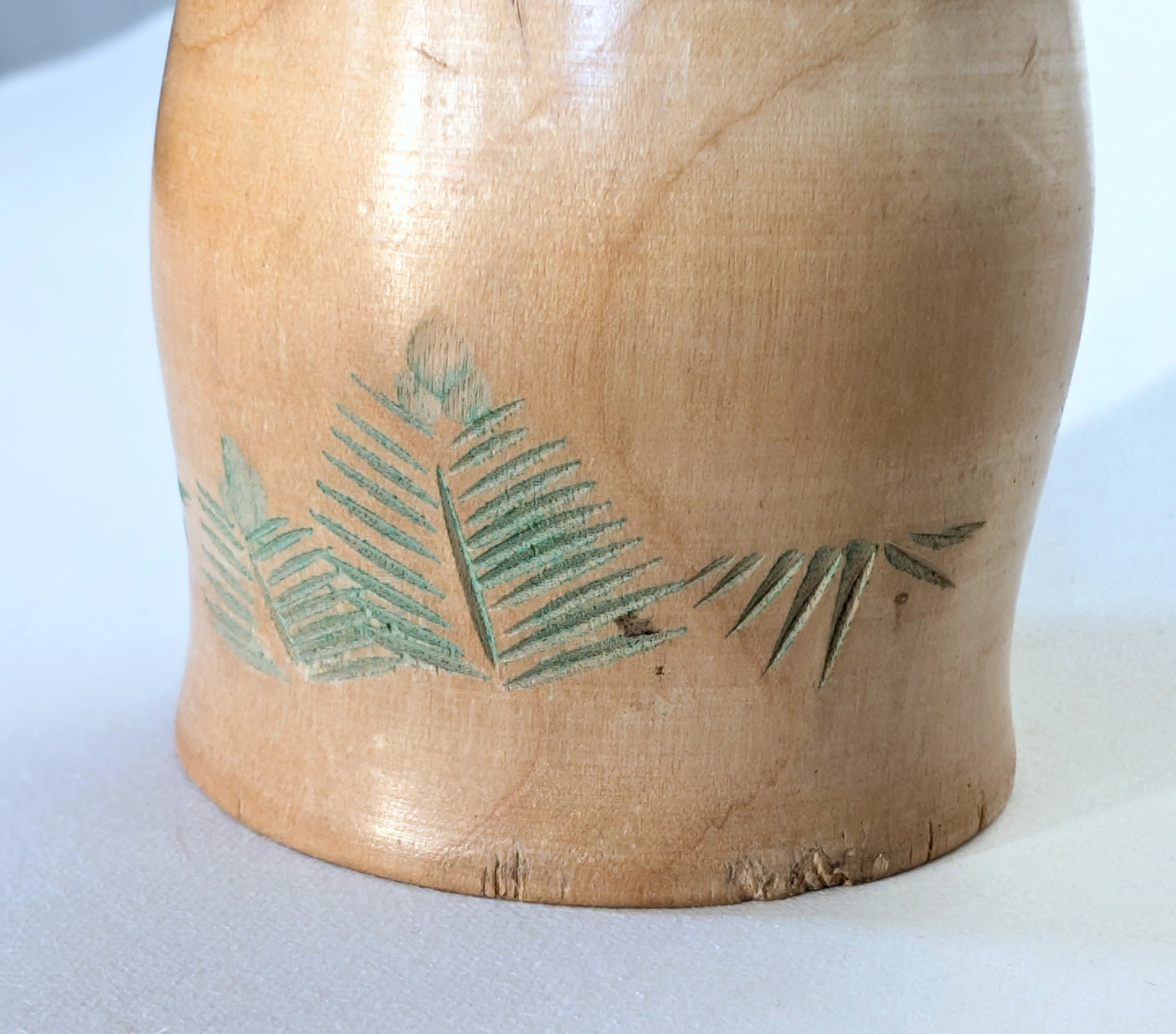 Motifs gravés de feuilles sur la robe/karris de la kokeshi japonaise Ueda Izumi.