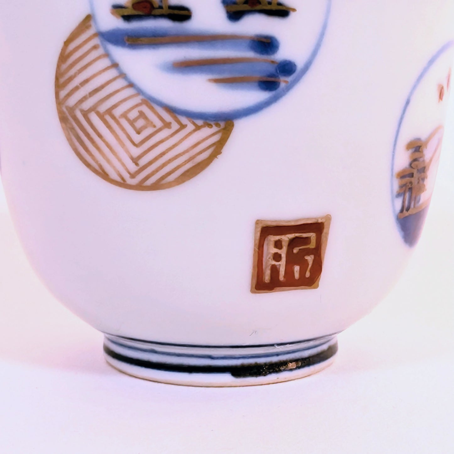 Détail de la dorure et de la marque Hizen sur un guinomi Arita en porcelaine Edo tardif.
