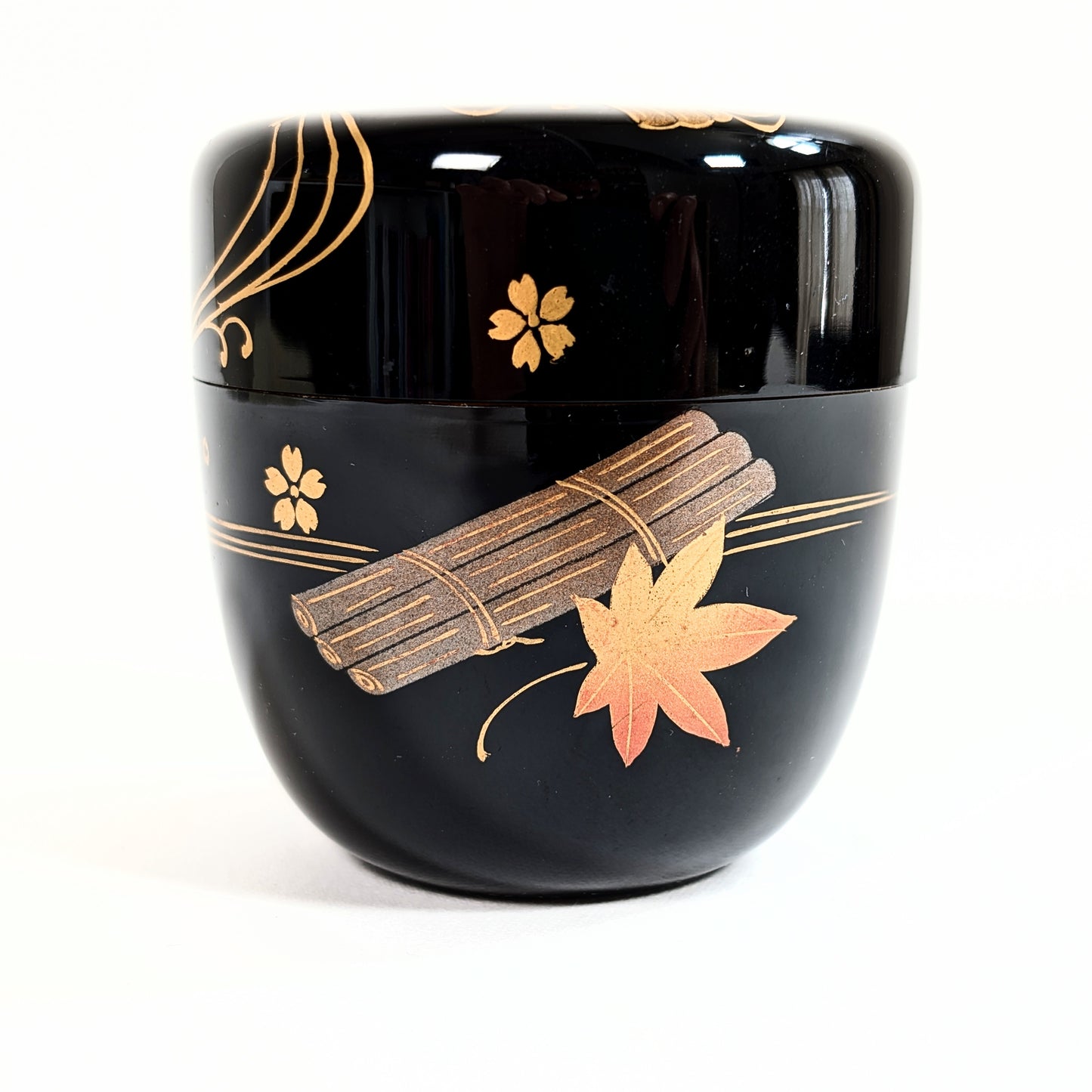 Détail du motif 花筏蒔絵 hanaikada maki-e avec momiji, sakura et lignes d’eau dorées sur laque japonaise noire