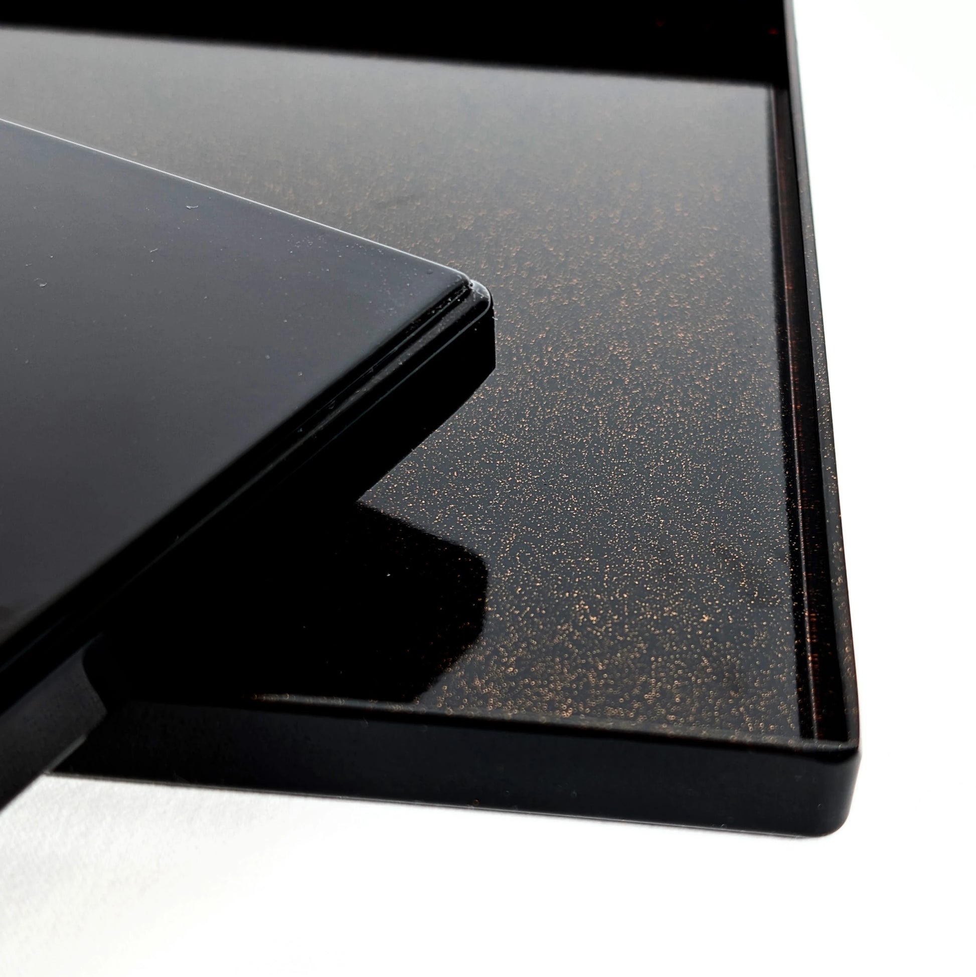 Détail du plateau intérieur en laque noire avec effet nashiji (poussière d’or), bord et angle.