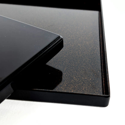 Détail du plateau intérieur en laque noire avec effet nashiji (poussière d’or), bord et angle.