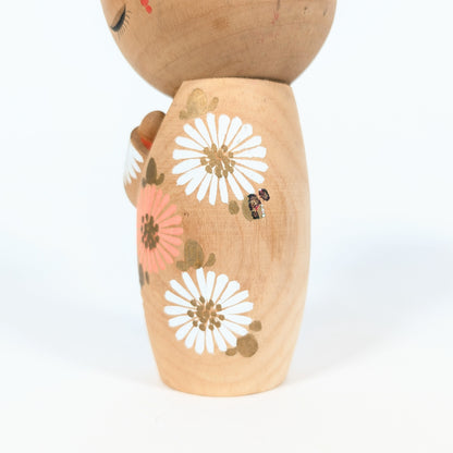 detail kokeshi fleurs japonaises blanches et roses marguerites hinagiku style sosaku artisanat traditionnel