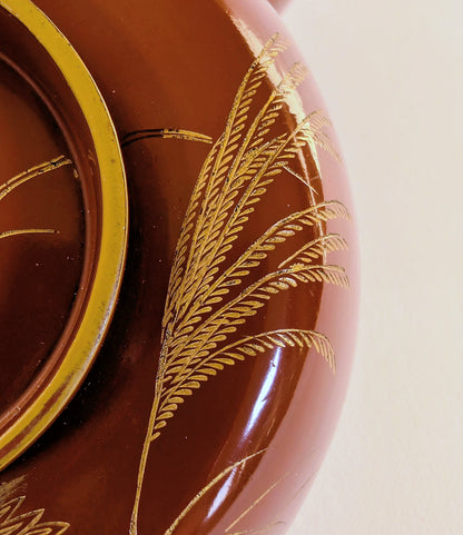 Détail en maki-e doré d’herbes susuki, symbole de l’automne japonais, sur laque urushi vermillon