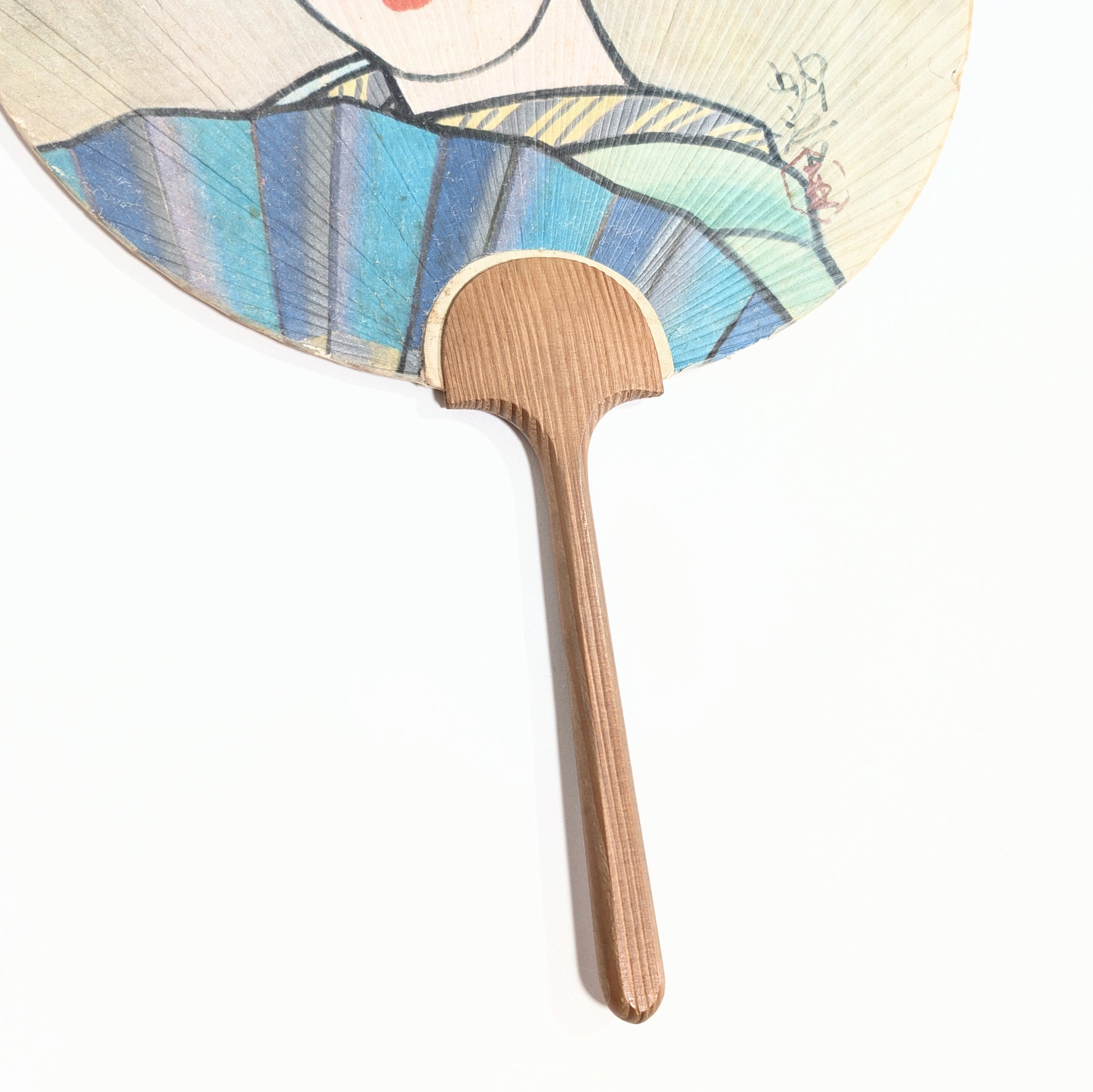 Détail du manche en bambou et du kimono bleu sur éventail uchiwa Mitsukoshi, artisanat japonais ancien en papier et bois