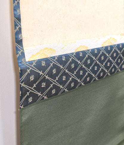 Détail du montage en soie d’un kakejiku japonais, avec papier washi, ichimonji doré et chūberi bleu à motif végétal