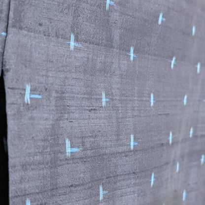 Détail du motif igeta-gasuri bleu clair sur la soie sombre d’un kimono japonais authentique