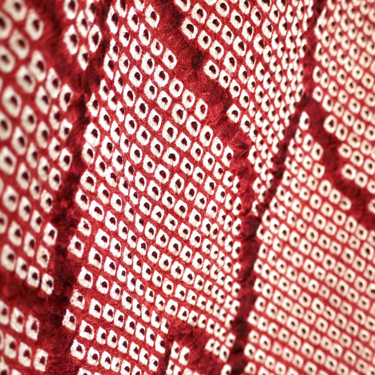 Détail du motif géométrique shibori rouge grenat sur soie, haori japonais