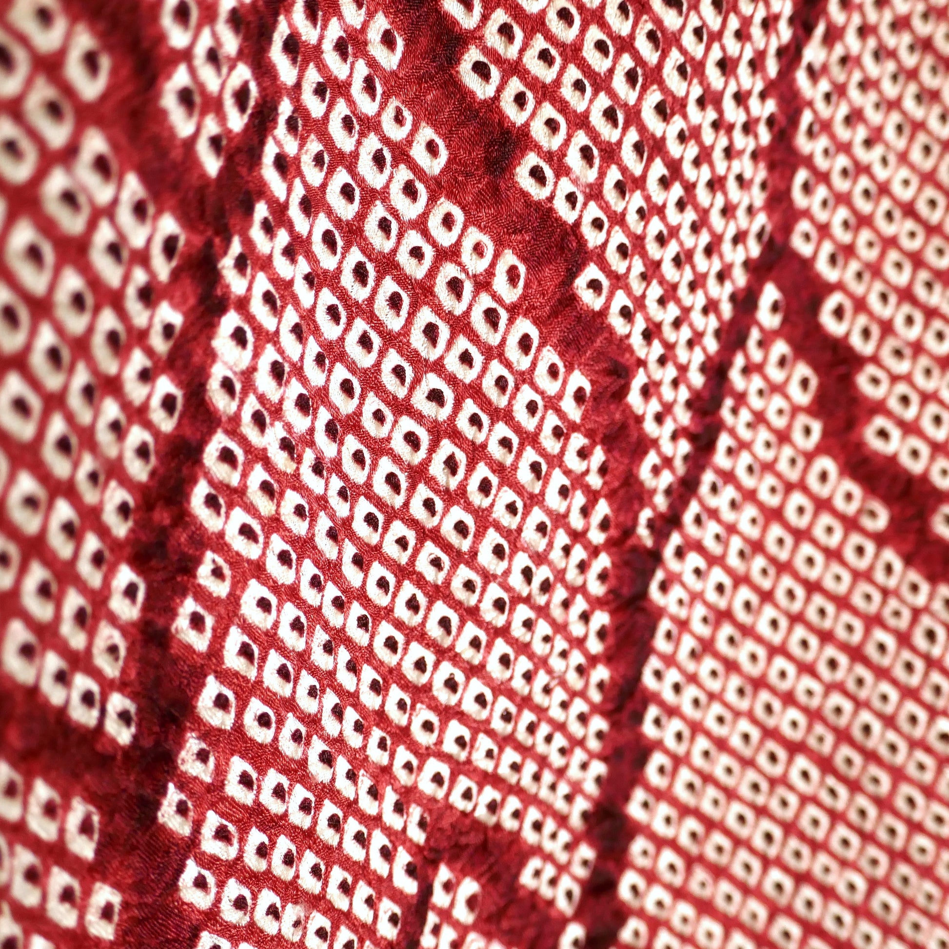 Détail du motif géométrique shibori rouge grenat sur soie, haori japonais