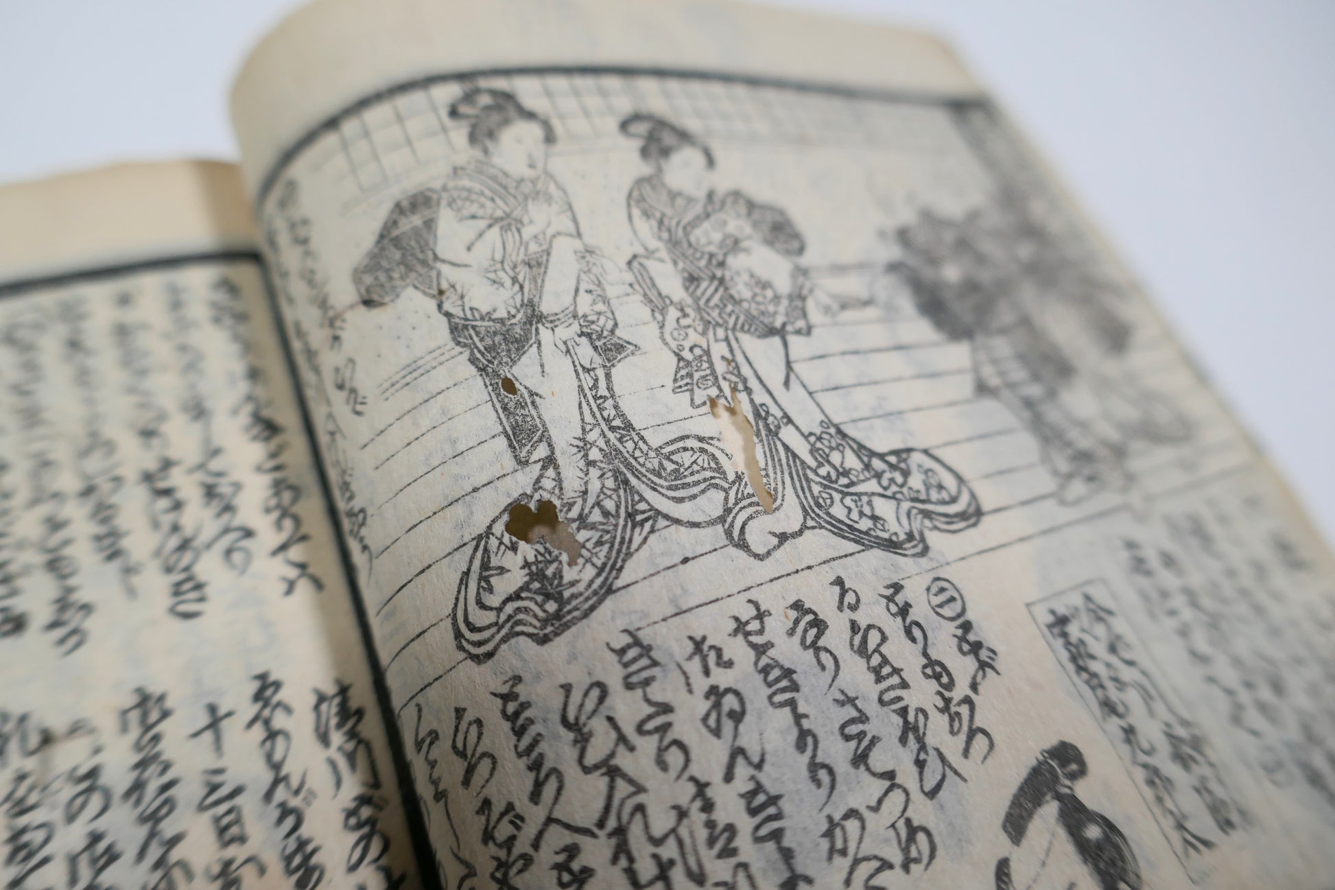 Gros plan sur le papier ancien et les estampes intérieures du Kinsei Bijin-roku, livre japonais Edo de collection avec texte gravé et scènes en kimono.