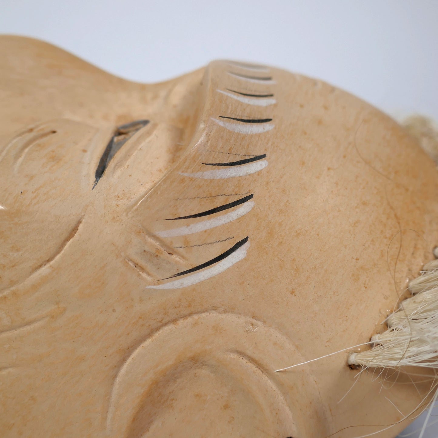 Détail des rides et sourcils peints d’un masque Nô japonais, nōmen ancien représentant un vieillard.