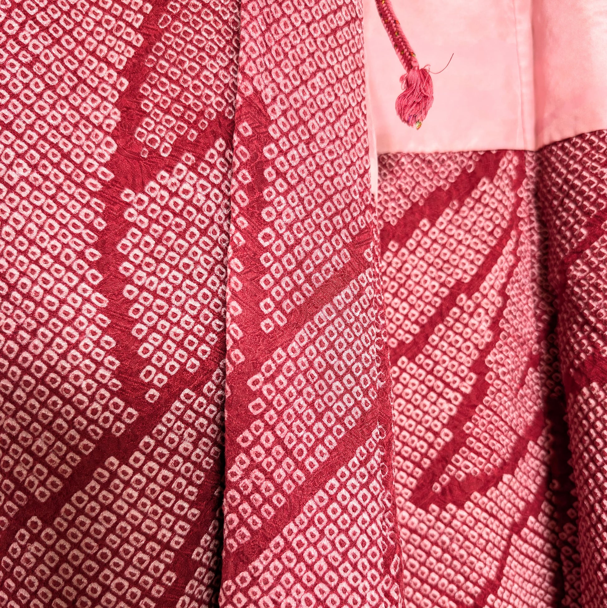 Détail d’un haori japonais femme en soie (正絹) teint en shibori (絞り), rose fuchsia, avec doublure motif nuages et brume.