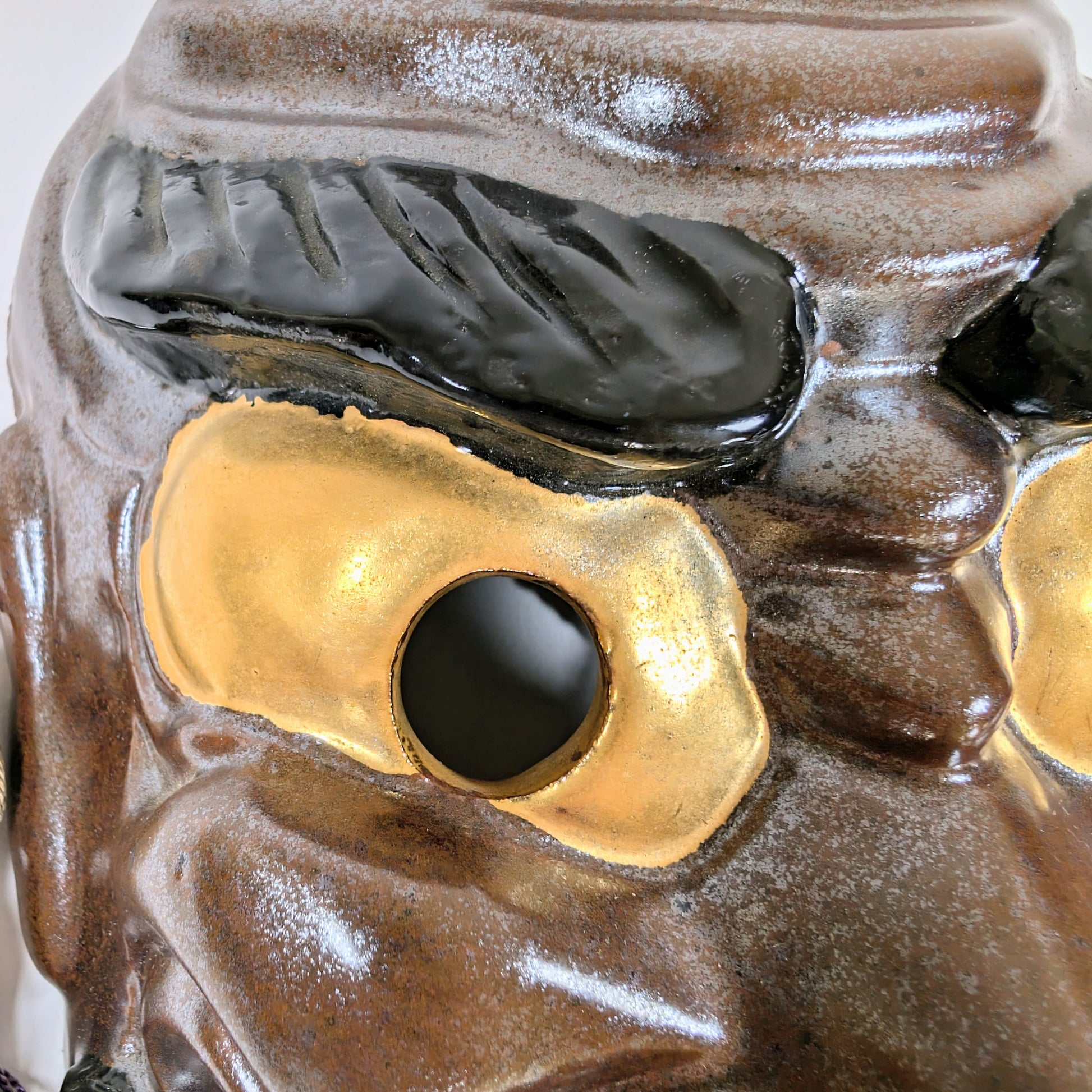 Détail des yeux dorés et sourcils noirs du masque Nô en Kutani-yaki de Susanoo, signé Matsuda Sokawa