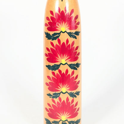 Détail des motifs kasane giku sur une kokeshi japonaise, grands chrysanthèmes rouges avec centres jaunes et feuilles vertes.
