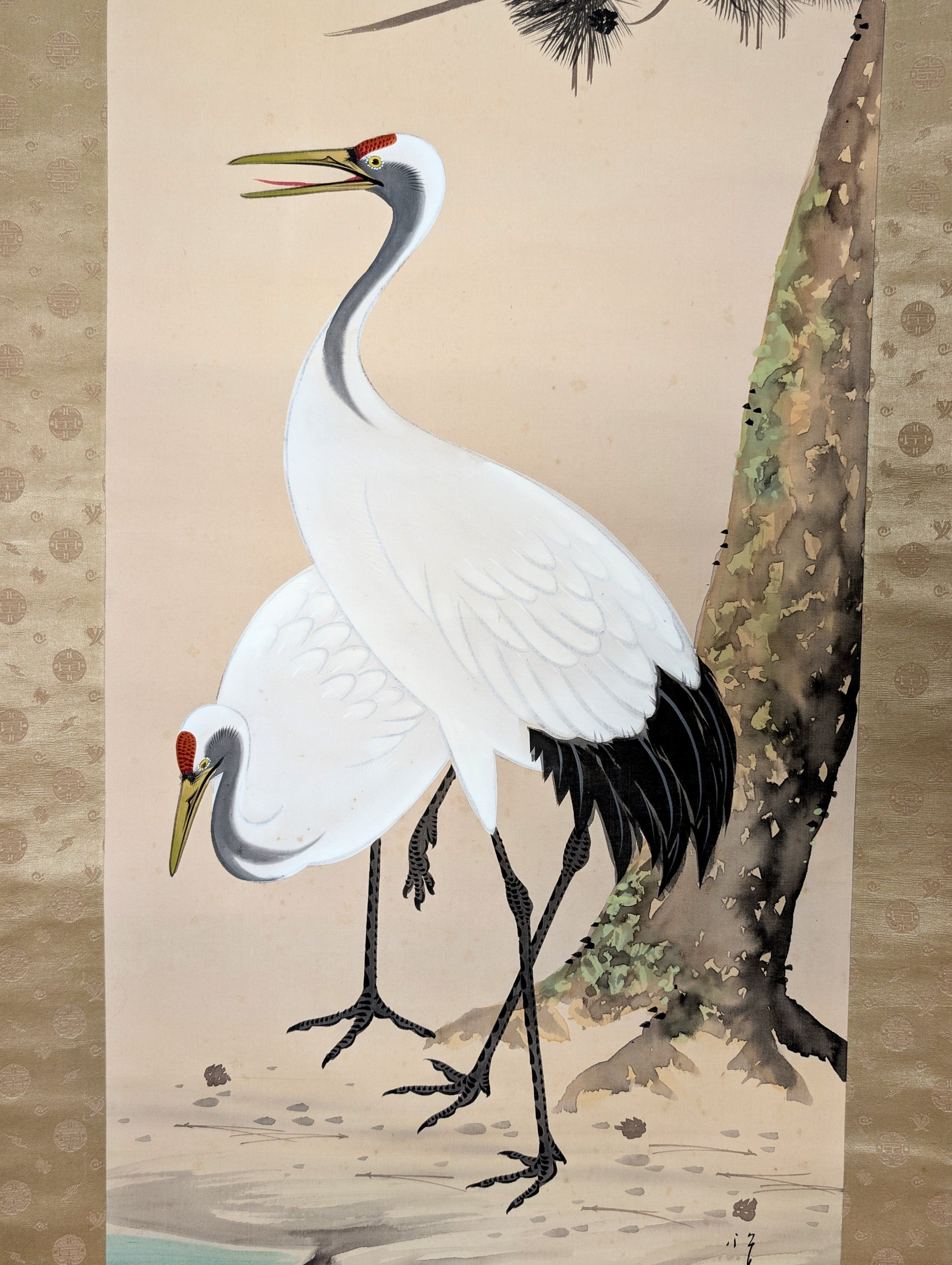 Détail des deux grues tsuru sous un pin, motif kachōga peint à la main sur soie dans ce kakemono japonais.