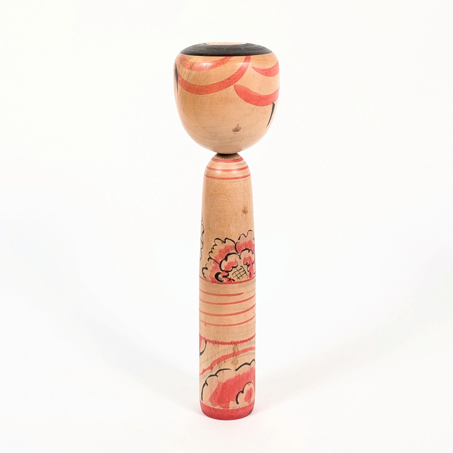 Dos de kokeshi Nakanosawa montrant la coiffure janome et les motifs rouges peints.