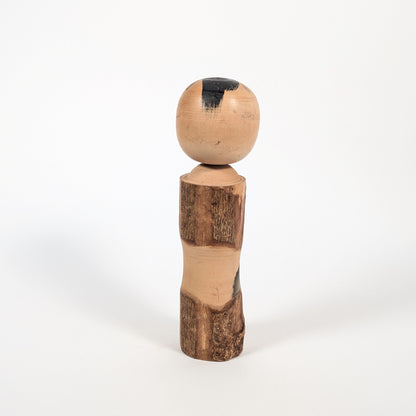 Dos d’une kokeshi omiyage Sato Kôson, corps en bois texturé façon écorce et patine vintage d’art populaire japonais.
