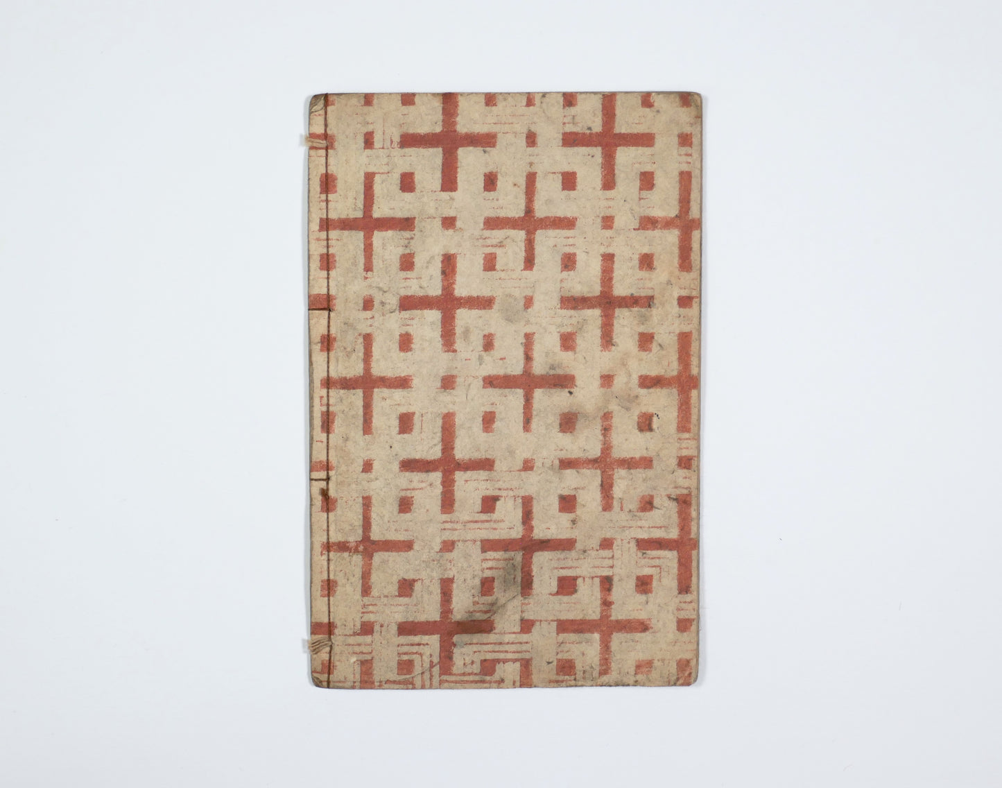 Dos et couverture arrière d’un e-hon Edo, livre japonais ancien cousu, antiquité japonaise avec papier décoré rouge.