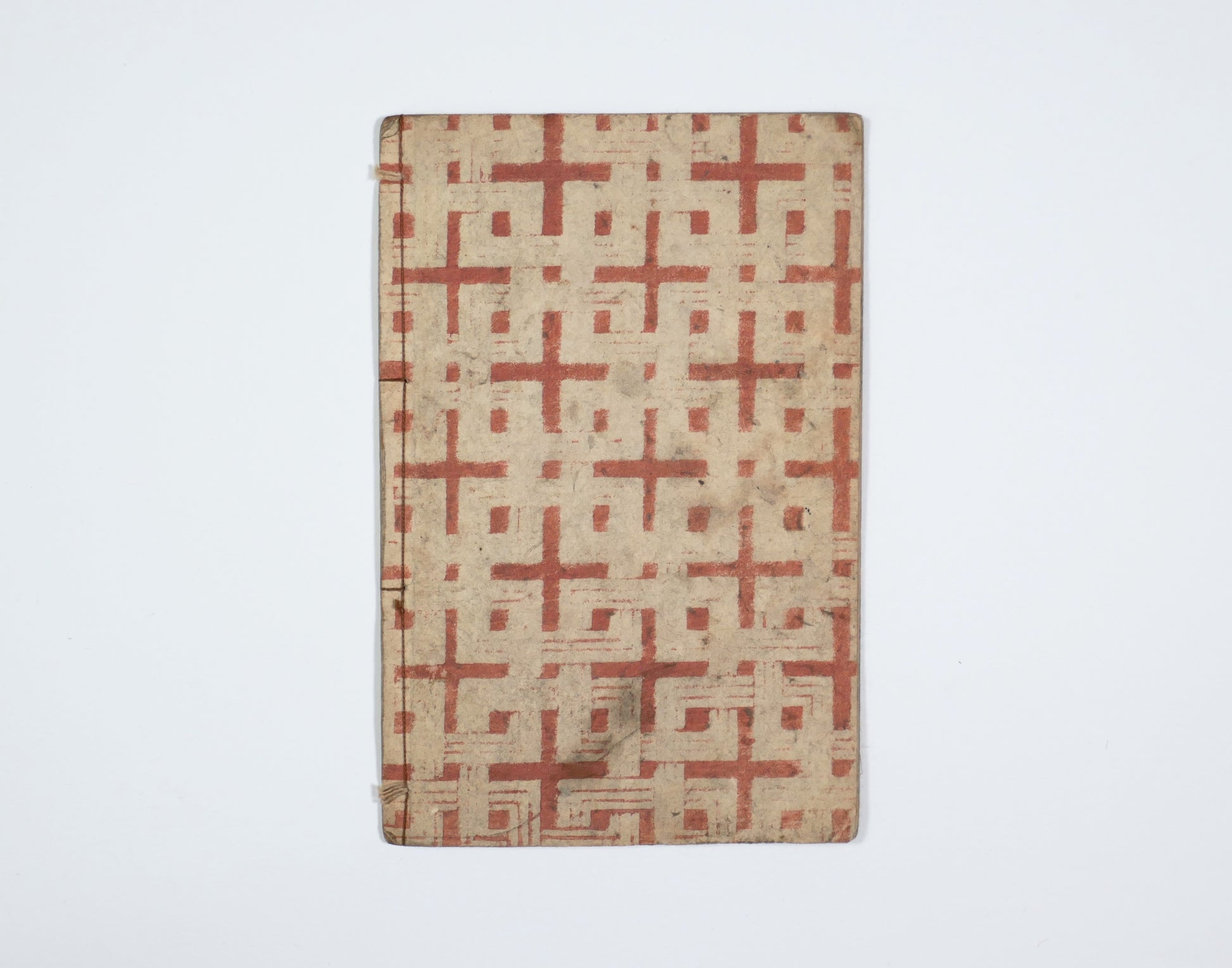 Dos et couverture arrière d’un e-hon Edo, livre japonais ancien cousu, antiquité japonaise avec papier décoré rouge.