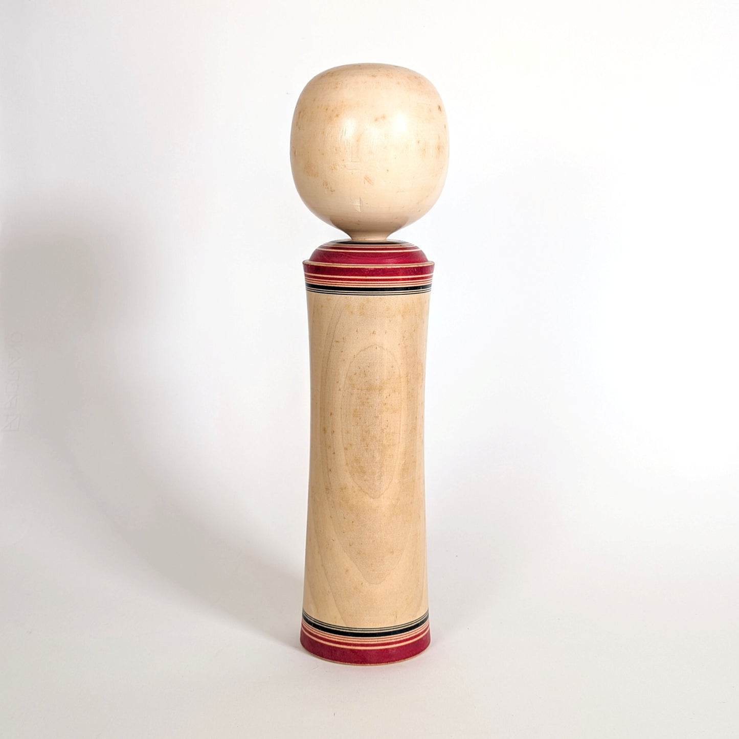 Dos d’une poupée japonaise kokeshi traditionnelle vintage en bois tourné avec patine du temps