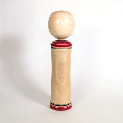 Dos d’une poupée japonaise kokeshi traditionnelle vintage en bois tourné avec patine du temps